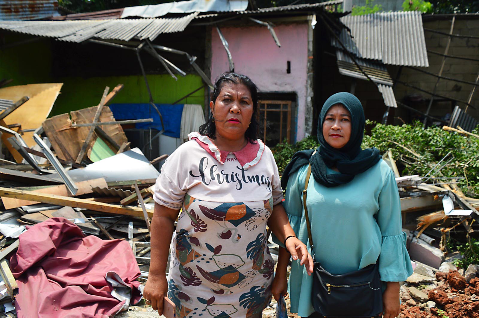 dok. Foto - Sri Sugesti (kiri) bersama adik perempuannya, Santi (kanan) berdiri di depan bangunan rumahnya yang telah di bongkar.